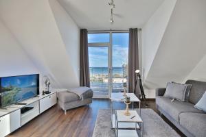 a living room with a couch and a tv at Haus Meeresrauschen Haus Meeresrauschen Appartement 1 6 in Haffkrug