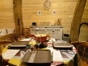 un comedor con una mesa en una cabaña en Charmant Gite 4 Places dans le Jura en Marigny