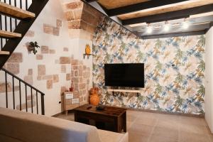 a living room with a flat screen tv on a wall at My Family Home-Casa Vacanze in Francavilla Fontana