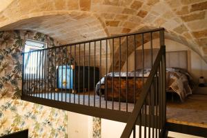 a staircase leading to a bedroom with a bed in a stone wall at My Family Home in Francavilla Fontana