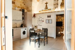 una cucina con tavolo e sedie in una stanza di My Family Home-Casa Vacanze a Francavilla Fontana