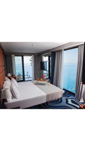 a bedroom with a large bed with a view of the ocean at Maritim Marina Bay Resort & Casino Adult Friendly in Vlorë