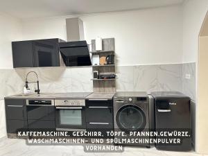 uma cozinha com um lavatório e uma máquina de lavar roupa em Suite Lombardi - Terrasse, Babybett, Doppelbett, Waschmaschine, Ruhige Lage em Bieber