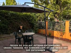 een tafel en stoelen onder een parasol op een patio bij Suite Lombardi - Terrasse, Babybett, Doppelbett, Waschmaschine, Ruhige Lage in Bieber