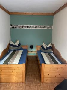 two beds in a room with blue walls at Ferienwohnung Jank in Jenig