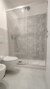 uma casa de banho com um chuveiro, um WC e um lavatório. em Barberini Bright Apartment em Roma