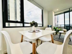 een witte eetkamer met een witte tafel en witte stoelen bij Best View 2br1ba 40floor In Cbd Balcony Wifi in Melbourne