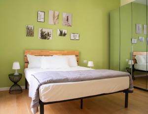 um quarto com uma cama com paredes verdes em Barberini Bright Apartment em Roma