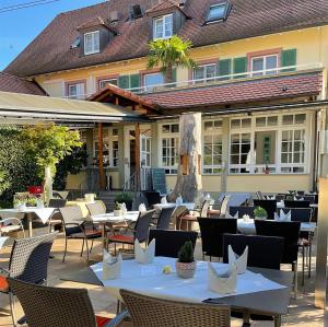 ein Restaurant mit Tischen und Stühlen vor einem Gebäude in der Unterkunft Landgasthof Rebstock Weil am Rhein / Basel in Weil am Rhein