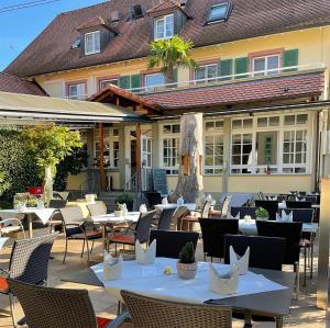 um restaurante com mesas e cadeiras em frente a um edifício em Landgasthof Rebstock Weil am Rhein / Basel em Weil am Rhein