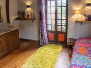 Schlafzimmer mit einem Bett, einem Fenster und einem Teppich in der Unterkunft Gîte d'étape la P'tite Graine in Auvillar
