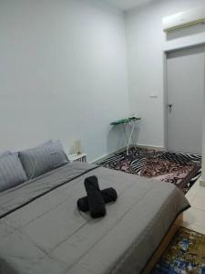a pair of black shoes sitting on a bed at Lakeview 3 Bedroom Apartment in Presint 18 Putrajaya in Putrajaya