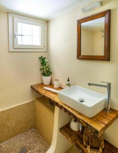 a bathroom with a sink and a mirror at Jasmine house in Sitia