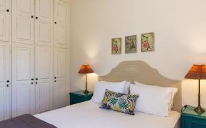 a bedroom with a white bed with two lamps at Jasmine house in Sitia