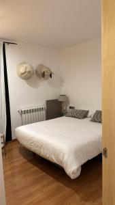 Un dormitorio con una cama blanca con un animal de peluche en la pared en Appartement au coeur d'Ordino, en Ordino