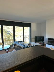 een woonkamer met een bank en een televisie bij Appartement au coeur d'Ordino HUT7872 in Ordino