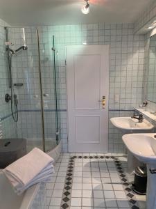 a bathroom with a shower and two sinks and a door at Haus Valentina in Archsum