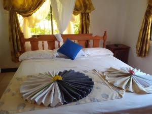 uma cama com duas almofadas em cima em Gigi's Self Catering Apartment em Port Glaud