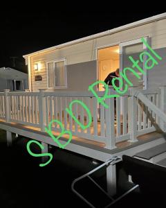 Saint Osyth的住宿－Summer Breeze Deluxe Caravan Rental，看着一所小房子的窗户的人