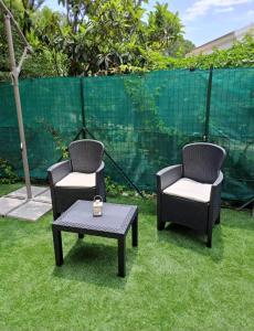 two chairs and a coffee table on the grass at Villetta vista mare a Praialonga in Le Castella