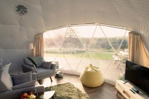 ein Wohnzimmer mit einem großen Fenster mit Aussicht in der Unterkunft Sunset Ridge - Luxury Geodesic Dome set in the beautiful countryside in Porkellis