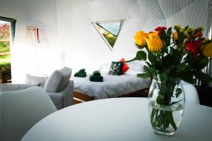eine Blumenvase auf einem Tisch in einem Zimmer in der Unterkunft Sunset Ridge - Luxury Geodesic Dome set in the beautiful countryside in Porkellis