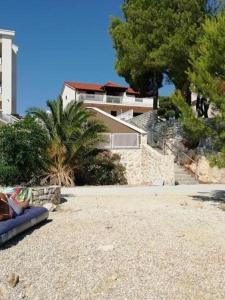 a couch sitting on the beach in front of a building at Apartments Belak in Brodarica