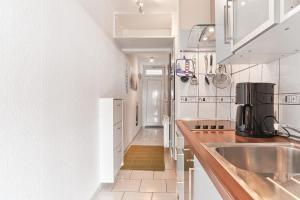 uma cozinha com armários brancos e um lavatório em Grömitz-Center Whg 5 em Grömitz