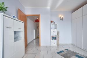 uma cozinha com armários brancos e um frigorífico em Grömitz-Center Whg 5 em Grömitz