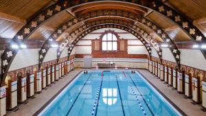 a swimming pool in a building with an arched ceiling at Hotel at Conference Aston in Birmingham