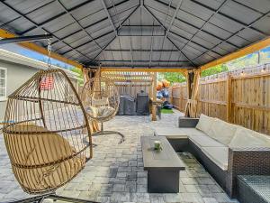 a patio with a couch and a swing at AMI, IMG, Beach, Bikes, Golf, Hottub, Fish, Beach, BBQ, SRQ in Bradenton
