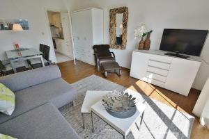 ein Wohnzimmer mit einem Sofa und einem TV in der Unterkunft Königsredder 23 Whg 3 in Grömitz