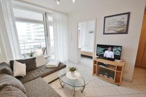 ein Wohnzimmer mit einem Sofa und einem TV in der Unterkunft Kaiserhof Whg 432 in Grömitz