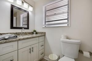 a bathroom with a toilet and a sink and a mirror at 3 bedroom House with Renovated kitchen and bath! in Cocoa
