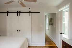 um quarto com uma cama branca e uma ventoinha de tecto em Shurs Lane Cottage, EV Charging, Free Parking em Filadélfia
