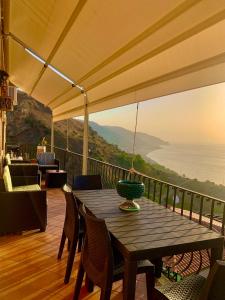 una mesa de madera con un jarrón en la parte superior de un balcón en 2 bedrooms apartement with sea view enclosed garden and wifi at Taormina 2 km away from the beach, en Taormina