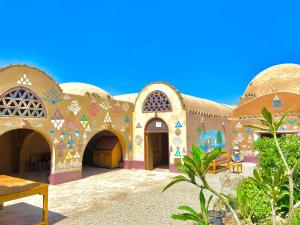 un bâtiment avec des mosaïques sur son côté dans l'établissement Kabara Nubian House, à Abou Simbel