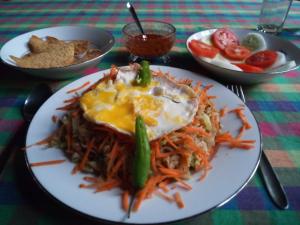 a plate of food with eggs and vegetables on a table at Lake Face Cabana in Tissamaharama