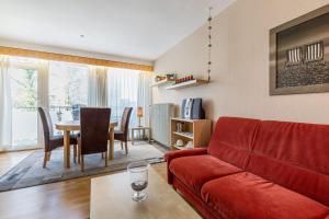 uma sala de estar com um sofá vermelho e uma mesa em Nautilus Whg 19 em Grömitz