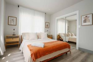 1 dormitorio con 1 cama grande con manta naranja en Modern 3BR Home in Pico Union near K-town and USC, en Los Ángeles