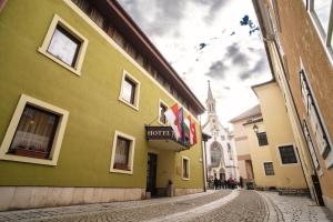 una calle en una ciudad con una iglesia en el fondo en Hotel Palatinus, en Sopron