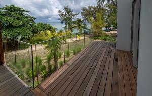 a wooden deck with a view of the ocean at Prestigious waterfront apartment with huge pool! in Pointe aux Piments