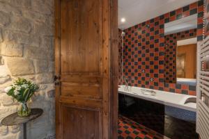 bagno con porta in legno e lavandino di Hôtel Prince de Conti a Parigi