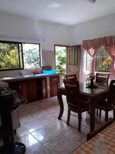 a kitchen with a table and chairs and a sink at Gigi's Self Catering Apartment in Port Glaud