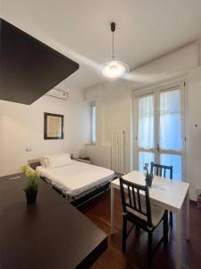 a bedroom with a bed and a table and chairs at Bocconi Apartment in Milan +2 photos