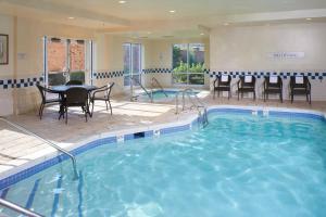 una gran piscina con sillas y una mesa en un hotel en Fairfield Inn & Suites Indianapolis East, en Indianápolis