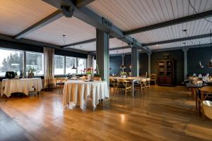 una sala da pranzo con tavoli, sedie e finestre di Millestgården Eco lodge a Duved