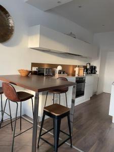 a kitchen with a table and stools in a room at Villa Sainte-Anne - Ploemeur in Ploemeur