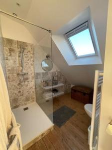 a bathroom with a shower with a toilet and a window at Villa Sainte-Anne - Ploemeur in Ploemeur