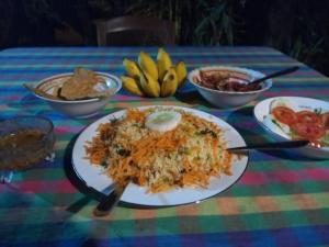a table with a plate of food on a table at Lake Face Cabana in Tissamaharama